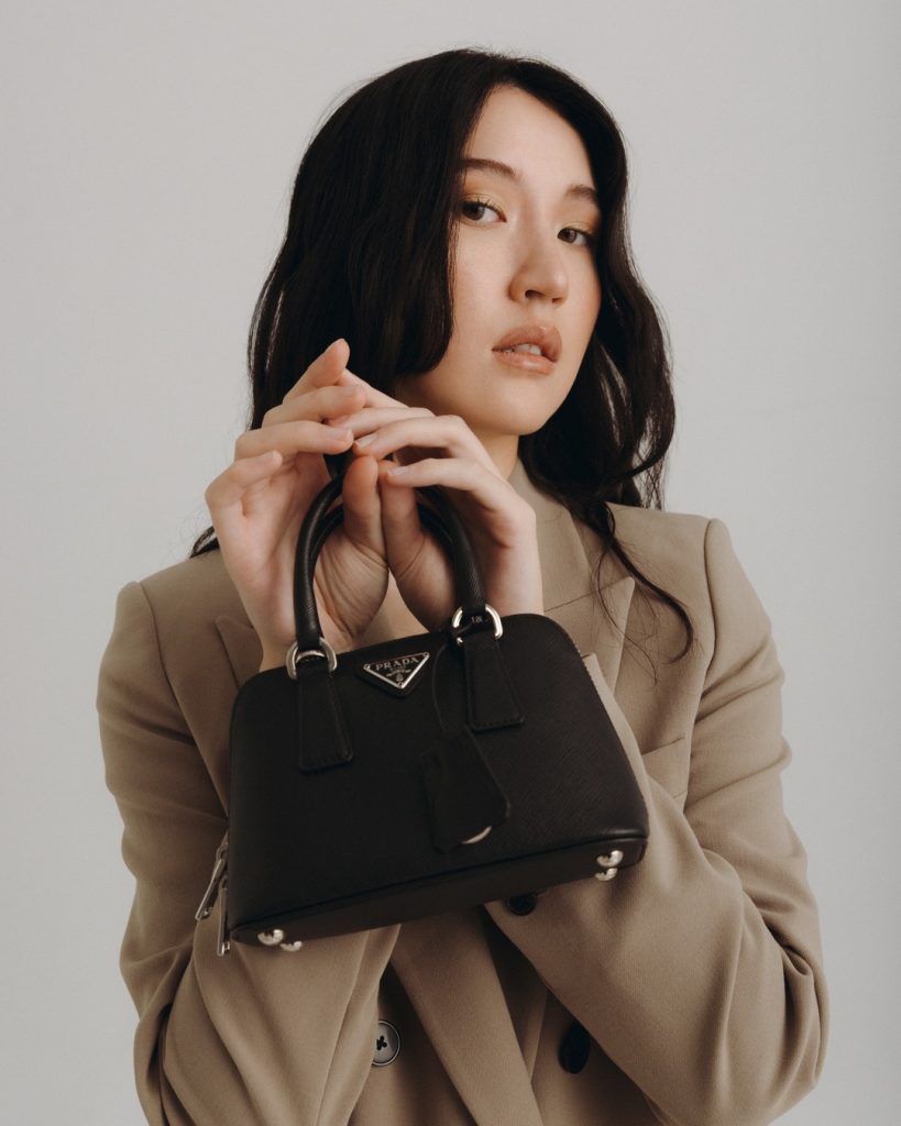 A woman holding a designer bag that she purchased on sale.